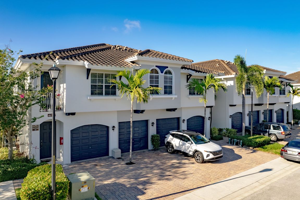 Spacious townhomes with attached garages in a peaceful, palm-lined community.