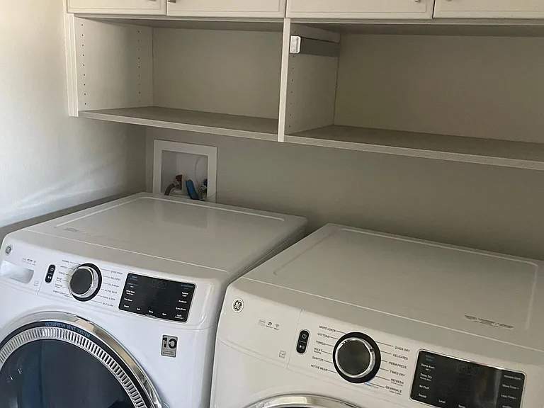 Laundry located in hallway to garage but I didn't forget about cabinetry. Large size with steam function to washer and dryer