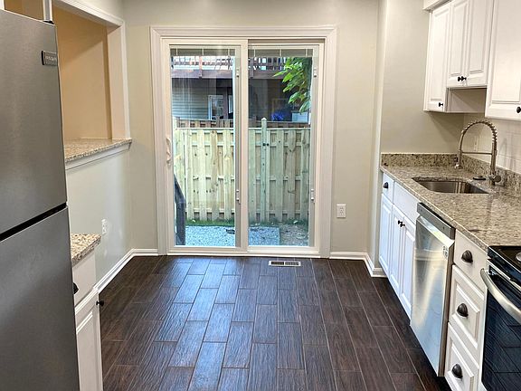 Well-lit kitchen access to fenced-in, back patio through new sliding glass door with built-in blinds.
