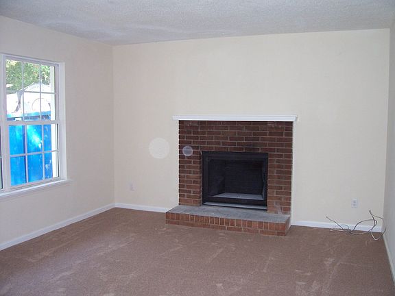 Great room with fireplace, new carpet and paint