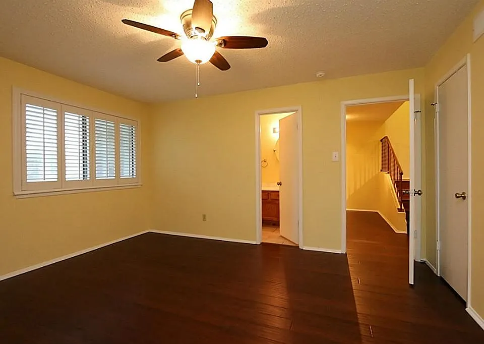 Bedroom downstairs with door to bathroom #3. New ceiling fan