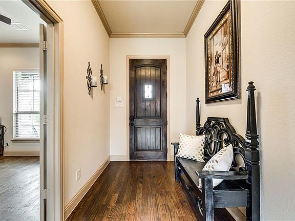 Heavy, knotty alder wood door with hand scraped wood flooring greet you as you enter the home!