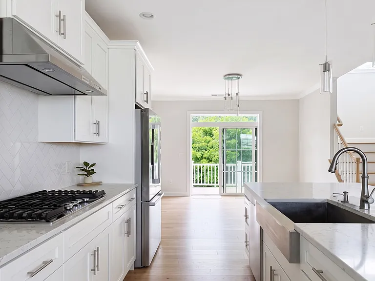 Seamless flow from kitchen into dining area with glass sliders to the private outdoor deck.