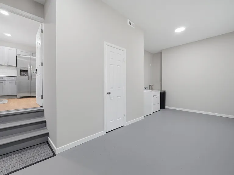Spacious flex area with recessed lighting, durable flooring, and easy access to the kitchen plus an in-unit laundry nook.