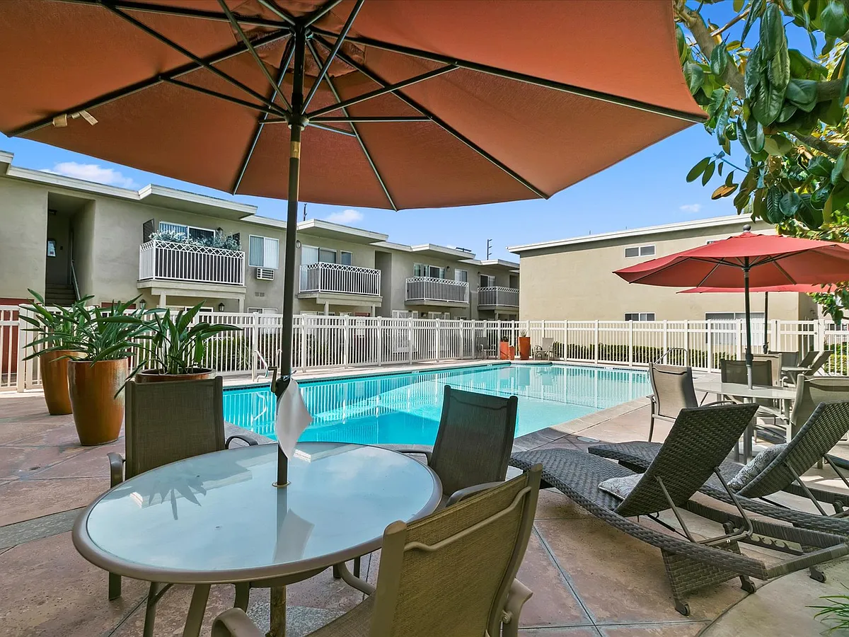 Outdoor relaxation area offering umbrella-shaded tables and resident lounge seating - 16628 Woodruff