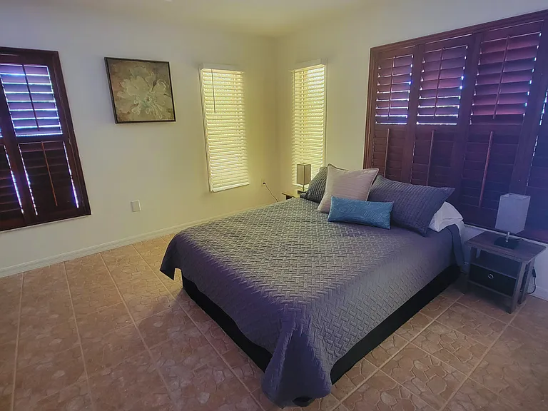 Inviting queen bed with plush pillows, elegant decor, and warm natural light
