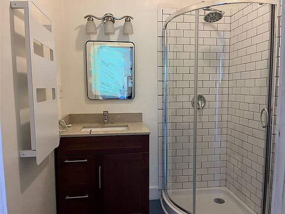 Bathroom includes a towel warmer, tiled shower, and new water-saving toilet.
