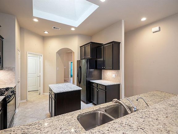 Kitchen with granite counters, skylight & refrigerator stays with sale. Plenty of cabinets for the gourmet chef.