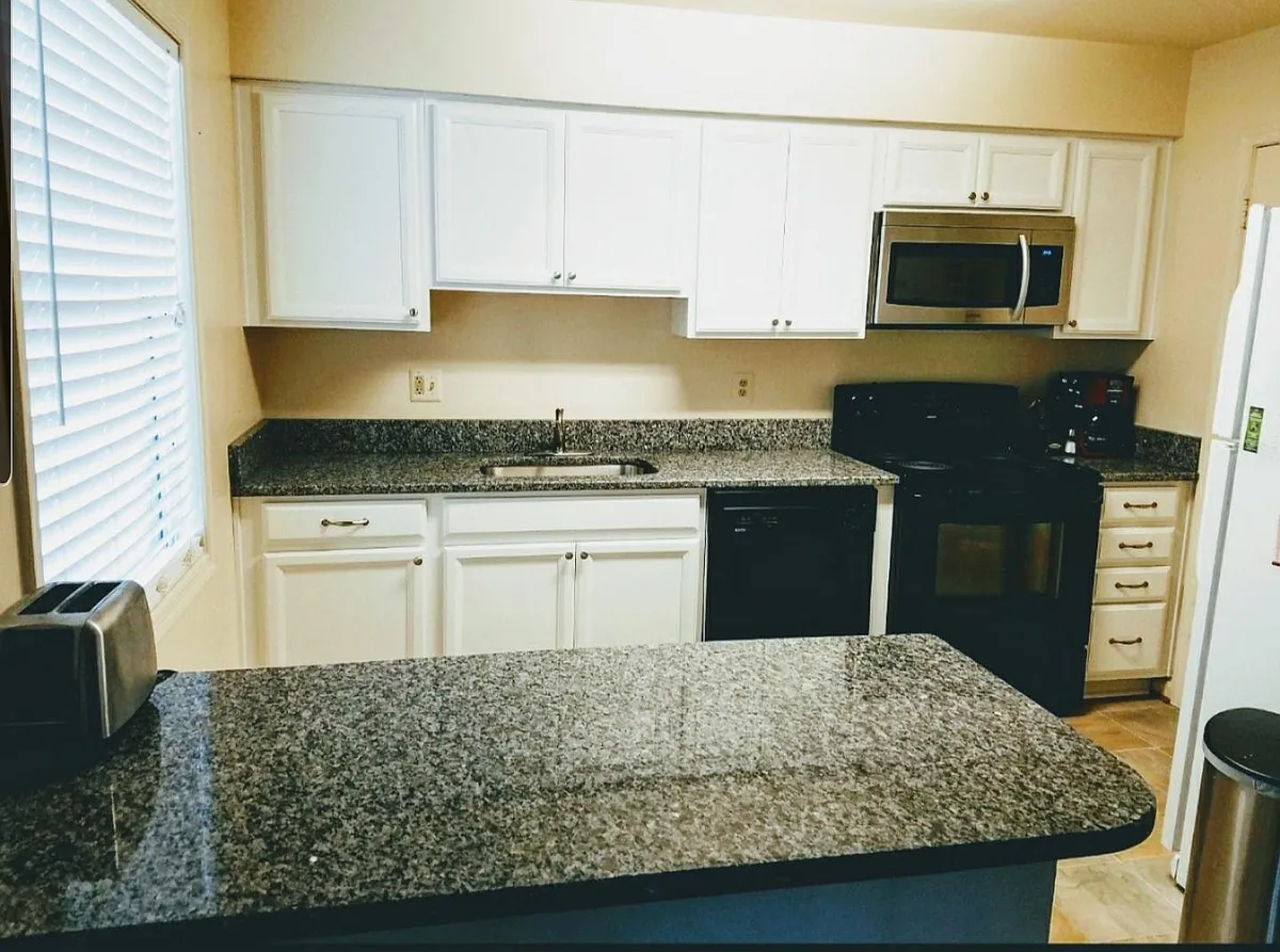 updated kitchen with white cabinets and beautiful granite countertops. - 8509 Sullivan Ct