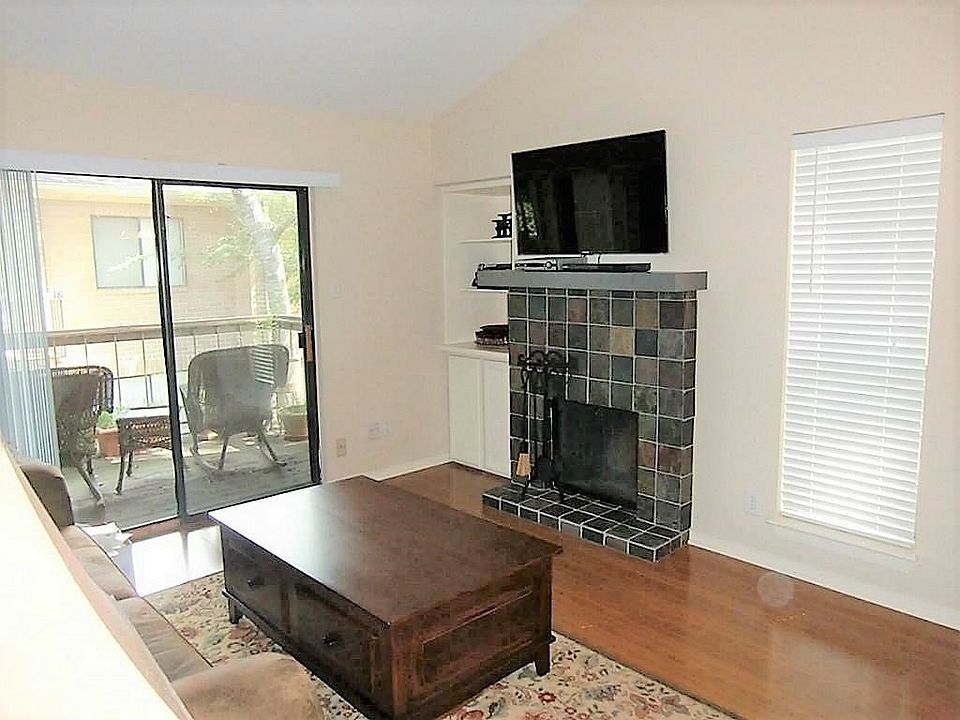 The living room has been updated with new floors, slate and wood mantel fireplace, outlet for TV above fireplace, cabinet replaced.  Enjoy the light and view of the balcony.