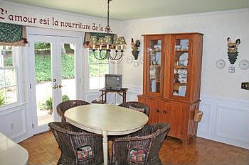 LARGE BRKFST AREA W/ DECORATIVE WAINSCOTING AND PATIO DOORS TO THE REAR PORCH.