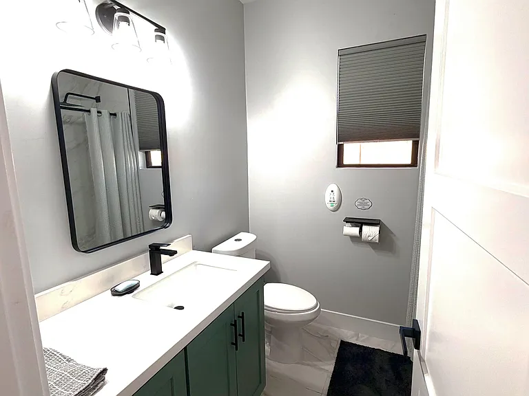 Updated bathroom with a single-sink vanity, framed mirror, and shower/tub combo, plus a window for ventilation