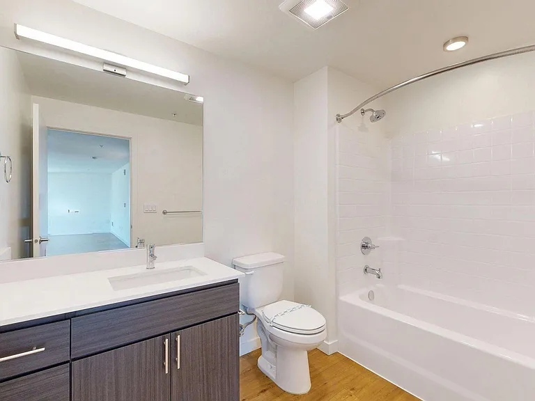 Apartment Bathroom with large soaking tub and wood-style flooring.
