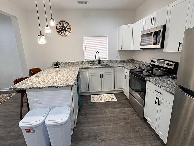 U-shaped kitchen with granite-look counters, breakfast bar seating, and stainless steel appliances for easy meal prep.