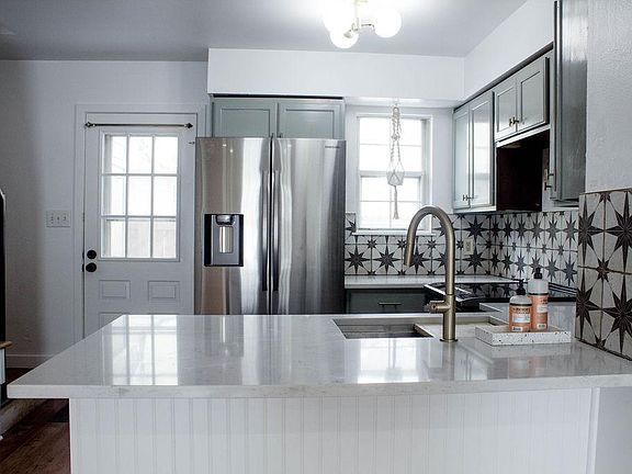 Newly renovated open kitchen with quartz countertops and stainless steel appliances (all included). Back door that opens to private patio.