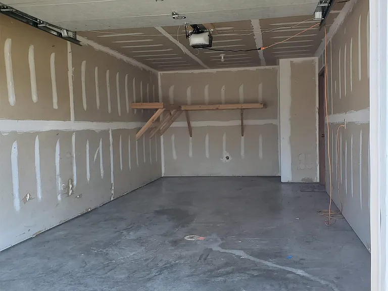 1 car garage with opener and shelves for storage.