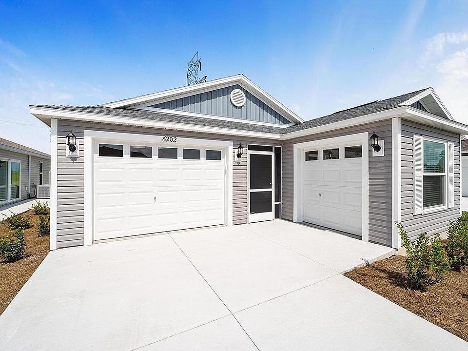 Front of Villa featuring a 1+ Car Garage and separate Golf Cart Garage.