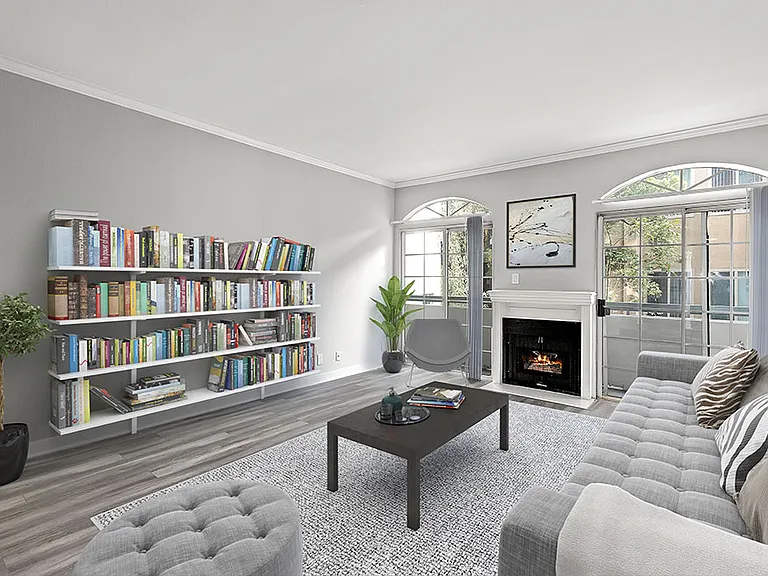 Large living room featuring hardwood floors and natural light providing adjacent patio.