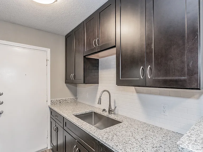 Enjoy cooking in stylish kitchens with dark cabinetry and granite-style counters at Chapel Creek Apartments.