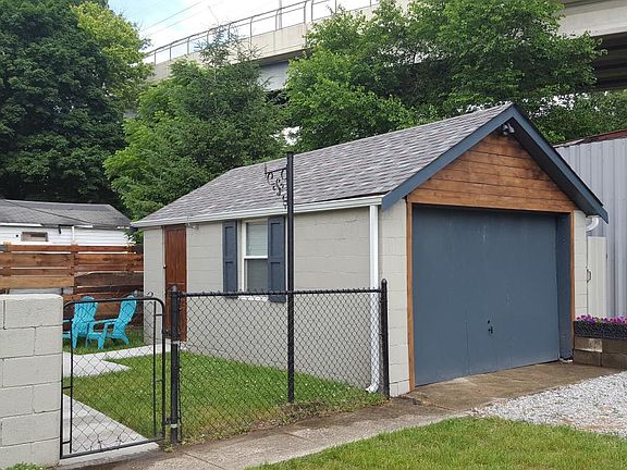 Adorable garage. The larger 1 was just removed leaving 2 more concrete parking spots
