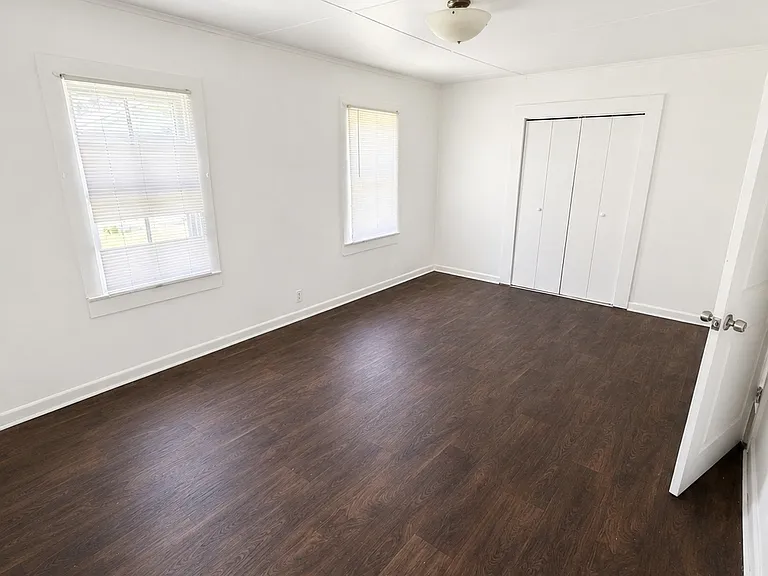 Large Primary Bedroom with beautiful flooring, two windows, and a generous closet.