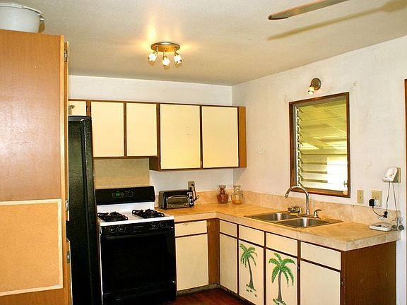 Kitchen has lots of cabinet storage and over the sink window looking out to co