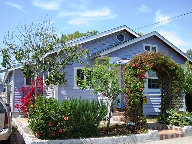 Earlier exterior photo showing the home's character and landscaping