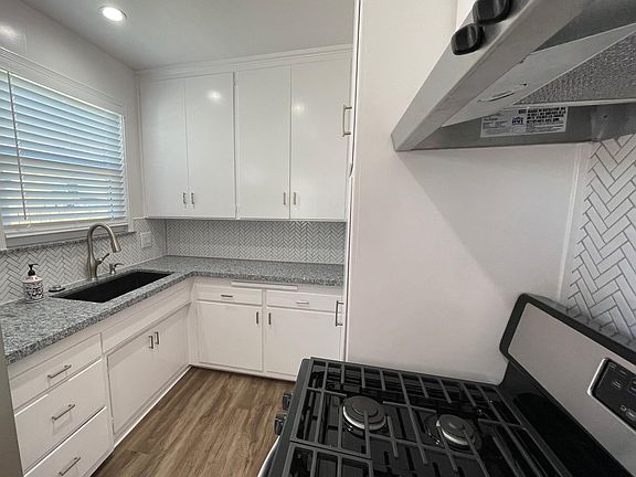 Kitchen includes NEW: windows, blinds, flooring, garbage disposal, plumbing, black granite sink, fixtures and recessed lighting.