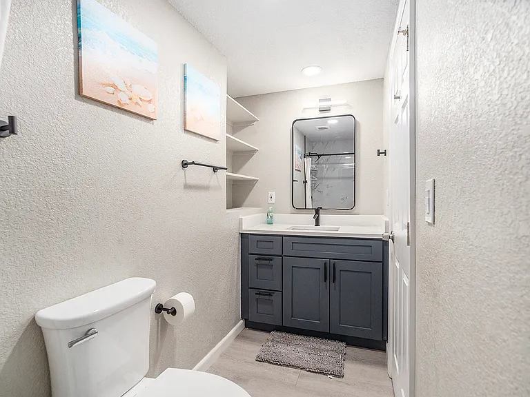 This bathroom has a single sink with a shower.