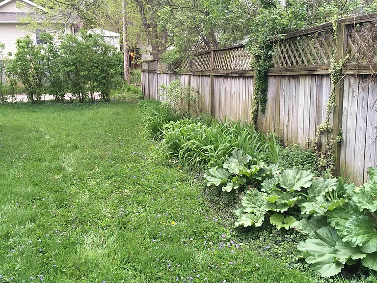 Private backyard with Hostas, Day Lillies, Irises, Rhubarb and large patio.