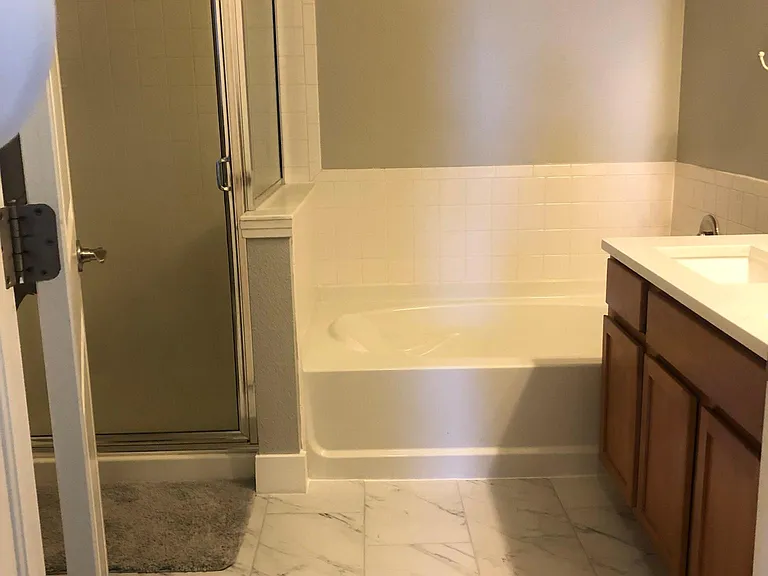 New marble-look tile flooring in this 5-piece master bathroom (separate shower and tub, with double vanity)