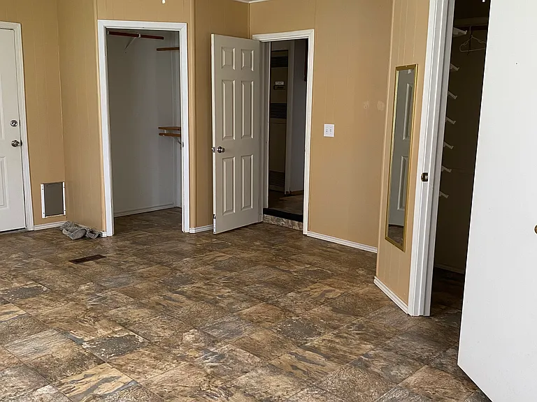 Master bedroom -door to far left goes to the back yard, smallest closet, entry door from hallway is open, far right is entry to largest walk-in closet with door open.