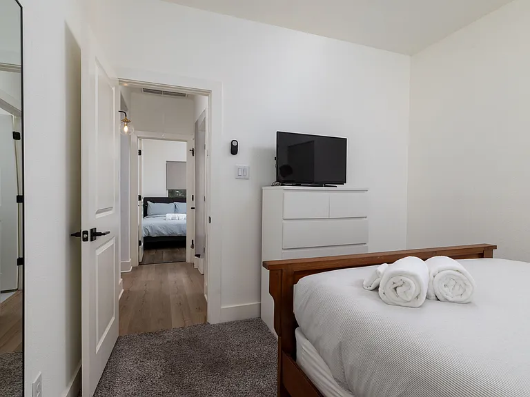 Second bedroom featuring queen bed and tv.