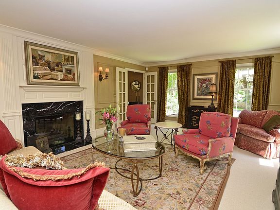 An elegant fireplace, with marble surround, vintage inspired wall scones. 