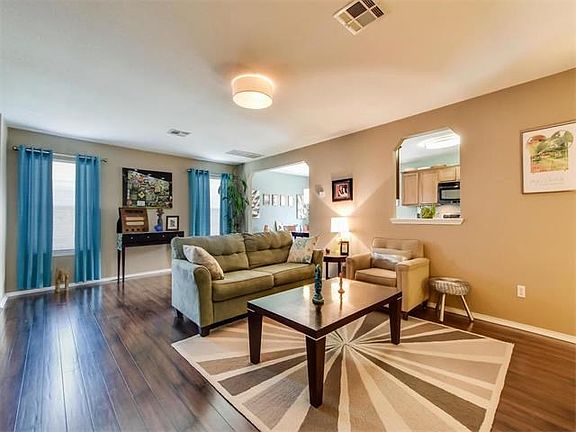 The family room opens to kitchen and dining area beyond. Recent laminate flooring and upgraded light fixtures are among the upgrades in this lovely home.
