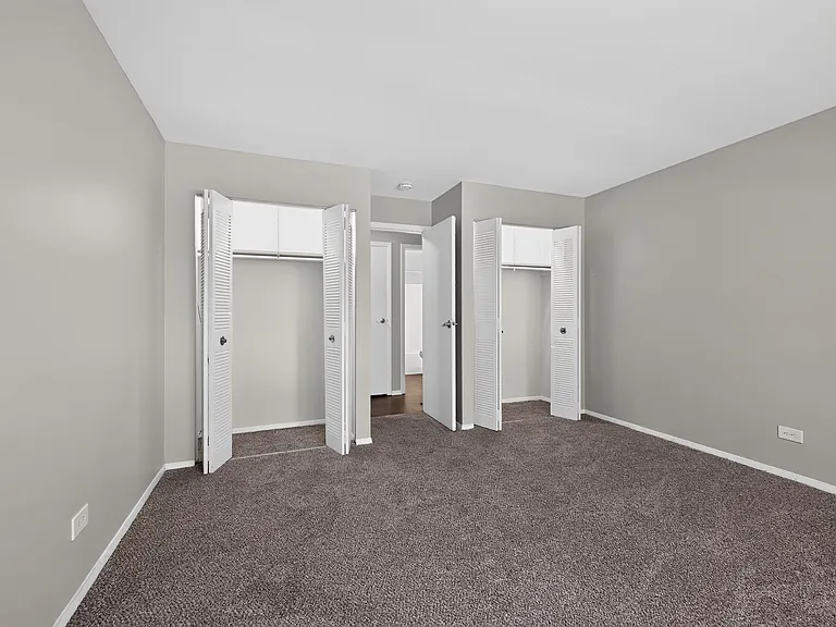 Enjoy a spacious bedroom featuring plush carpeting and generous closet space at Renaissance at Carol Stream in Carol Stream, IL.