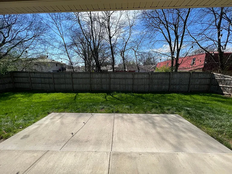 Backyard with covered patio and privacy fence. String lights included.