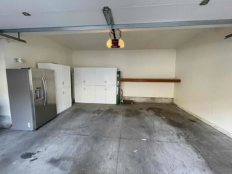 View inside from the garage. Multiple cabinets for storage. Brand new garage opener. Second refrigerator and freezer optional.