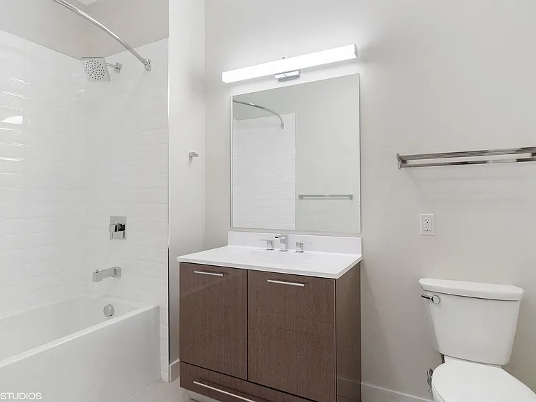 Bathrooms featuring frameless mirror with above mirror light