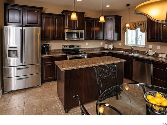Fabulous kitchen with island, staggered custom made cabinets, stainless steel appliances, oil rubbed