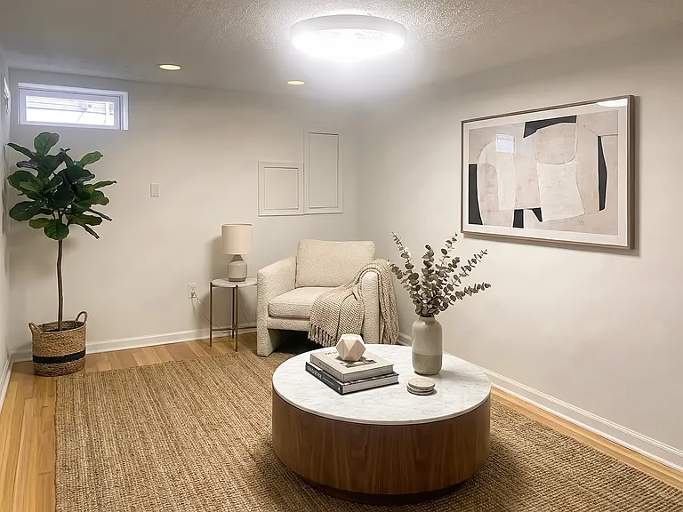 Bedroom view with a high window, modern ceiling light, and open floor space.
