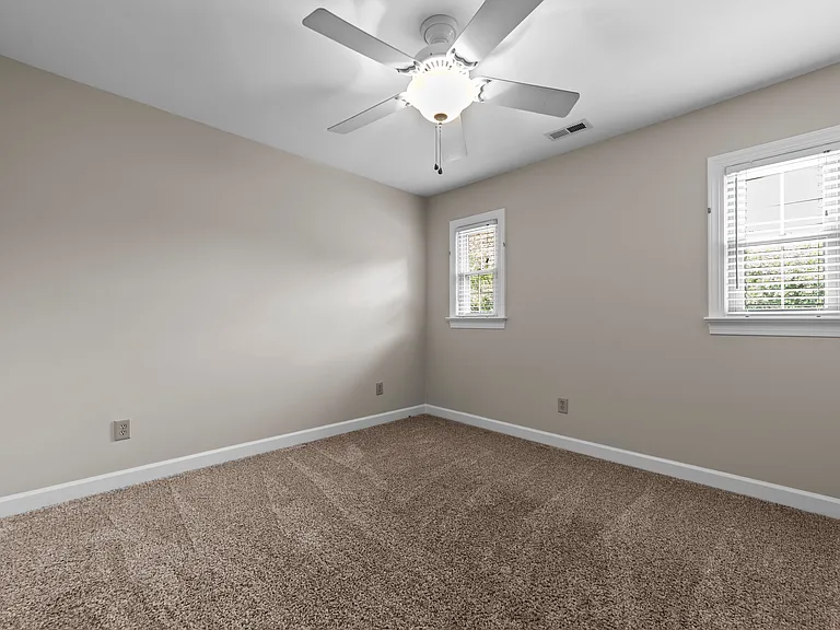 Additional bedroom or office with closet, ceiling fan, and flexible layout options.