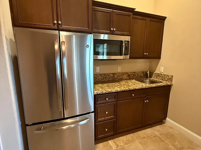 Small kitchenette area with a counter, sink and garbage disposal unit. Conventional microwave oven. ADU unit so no stove included. Plenty of cabinets, side by side refrigerator with freezer. There is also a medium size pantry.