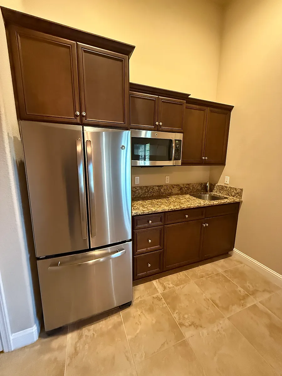 Small kitchenette area with a counter, sink and garbage disposal unit. Conventional microwave oven. ADU unit so no stove included. Plenty of cabinets, side by side refrigerator with freezer. There is also a medium size pantry. - 6717 W Oak Ave