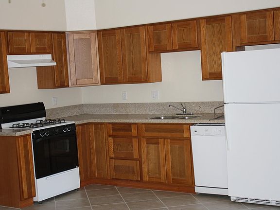 Light and bright Kitchen, granite countertops, Dishwasher, refrigerator, and range Tile floor