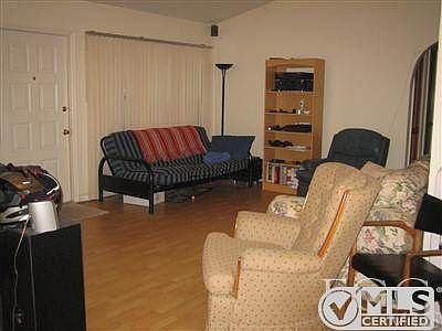 Living room with wood flooring, cathedral ceiling and tropic