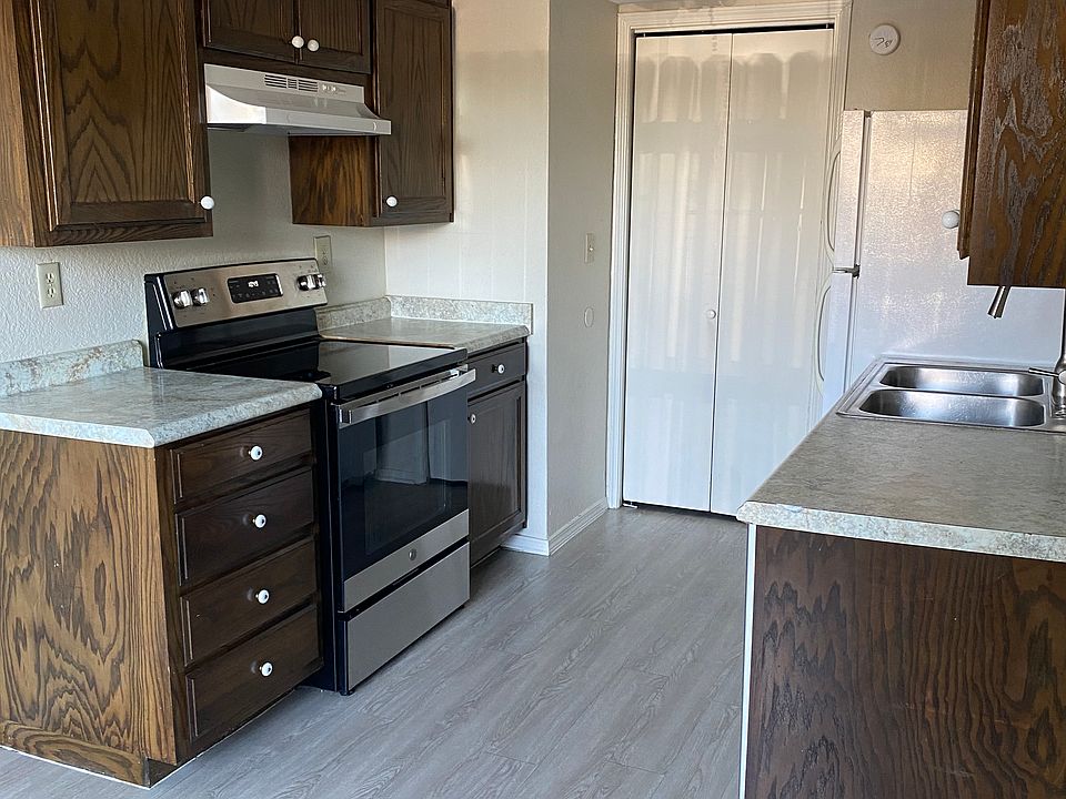Kitchen has cooktop stove, oven, dishwasher and refrigerator.