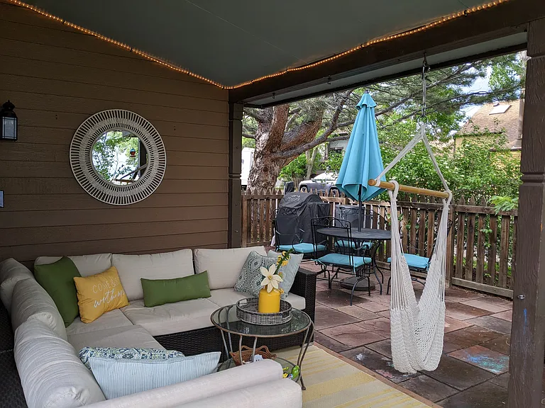 Large partially covered private patio with plenty of seating and an area for dining al fresco.