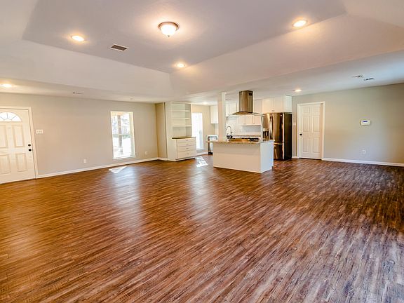 Open concept living room with tray ceiling and recessed lighting