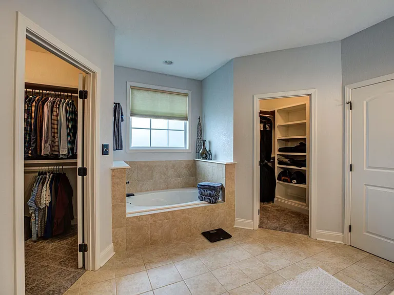 Master bathroom with two large with spa tub, dual head walk in shower, two large walk-in closets with added custom shelving.